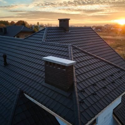 Snow guard for safety in winter on house roof top covered with ceramic shingles. Tiled covering of building.